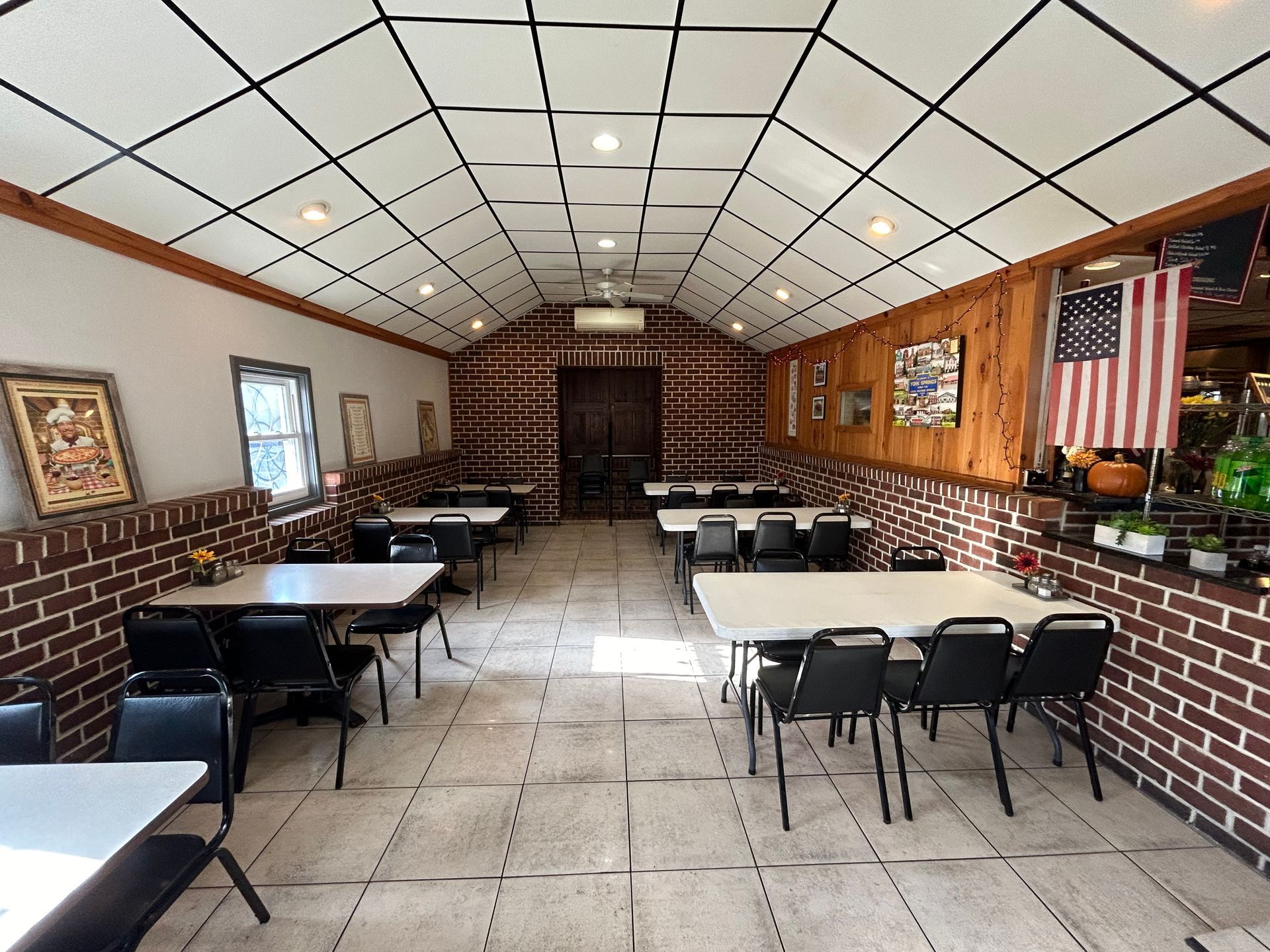 A long room with tables and chairs in a restaurant