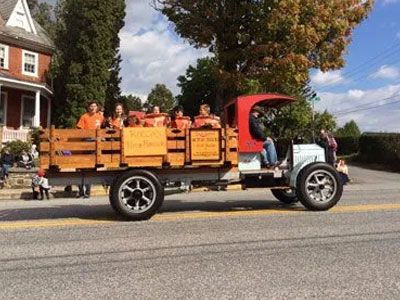 A group of people are riding in the back of an old truck.