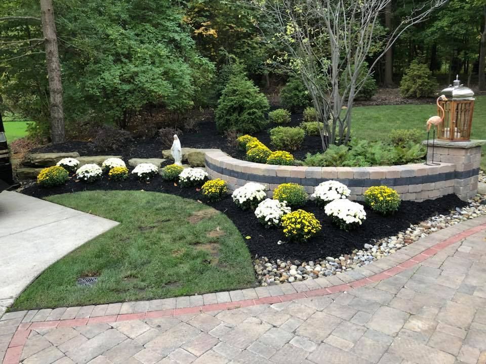 A garden with flowers and a flamingo in the background