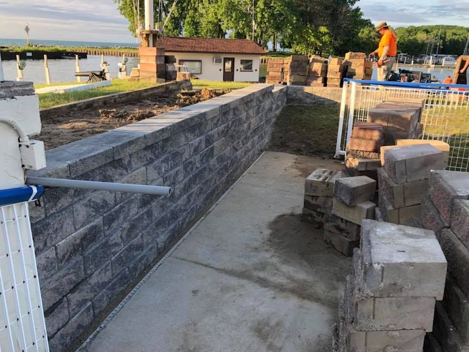 A brick wall is being built next to a body of water.