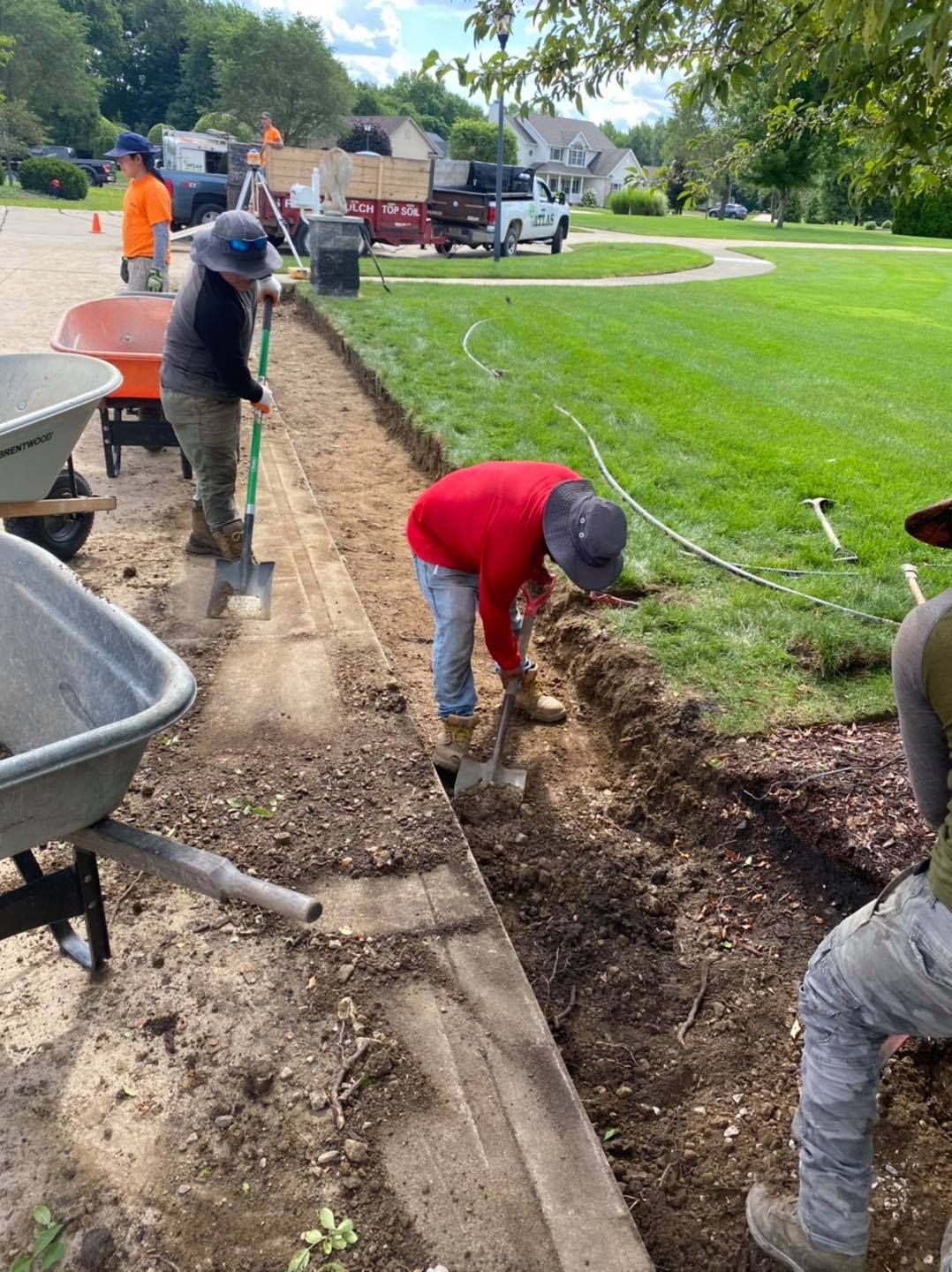 A group of construction workers are working on a sidewalk.
