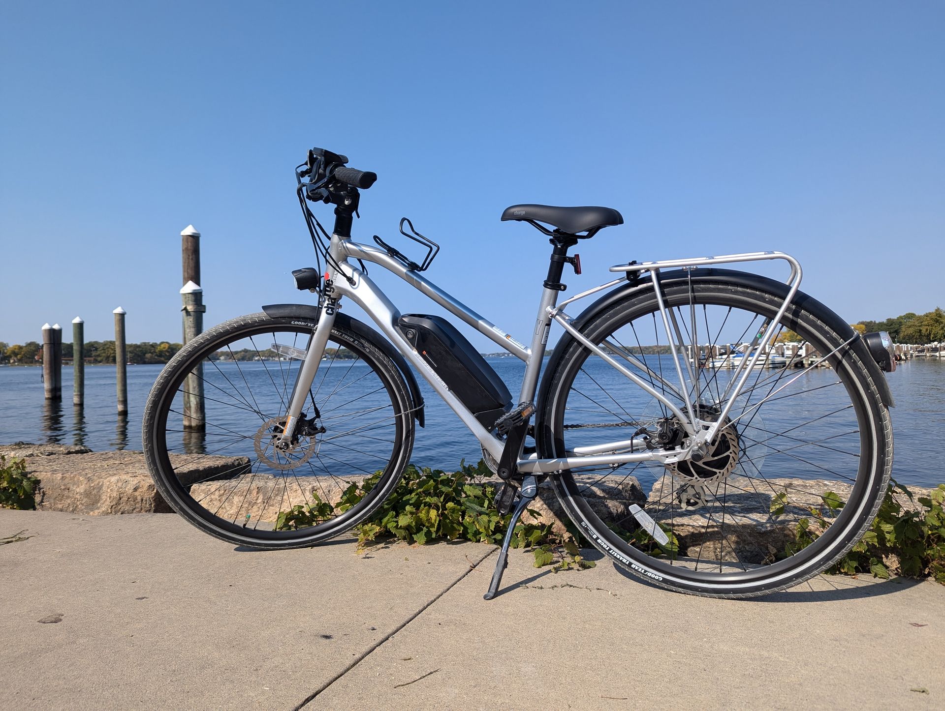 A bicycle is parked on a sidewalk next to a body of water.