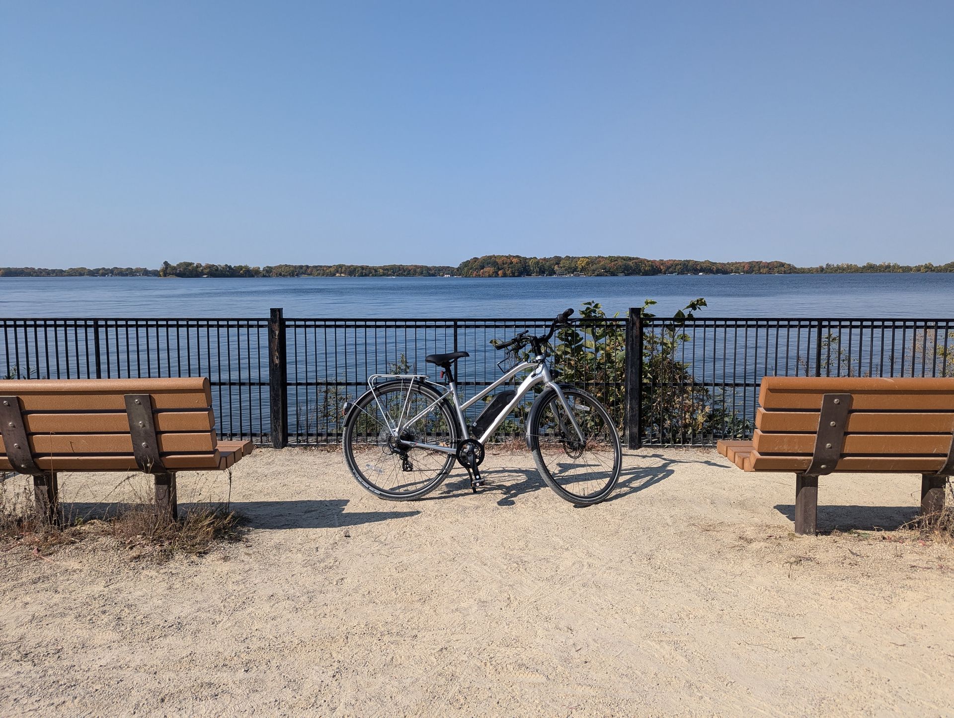 A bicycle is parked on a bench next to a body of water.