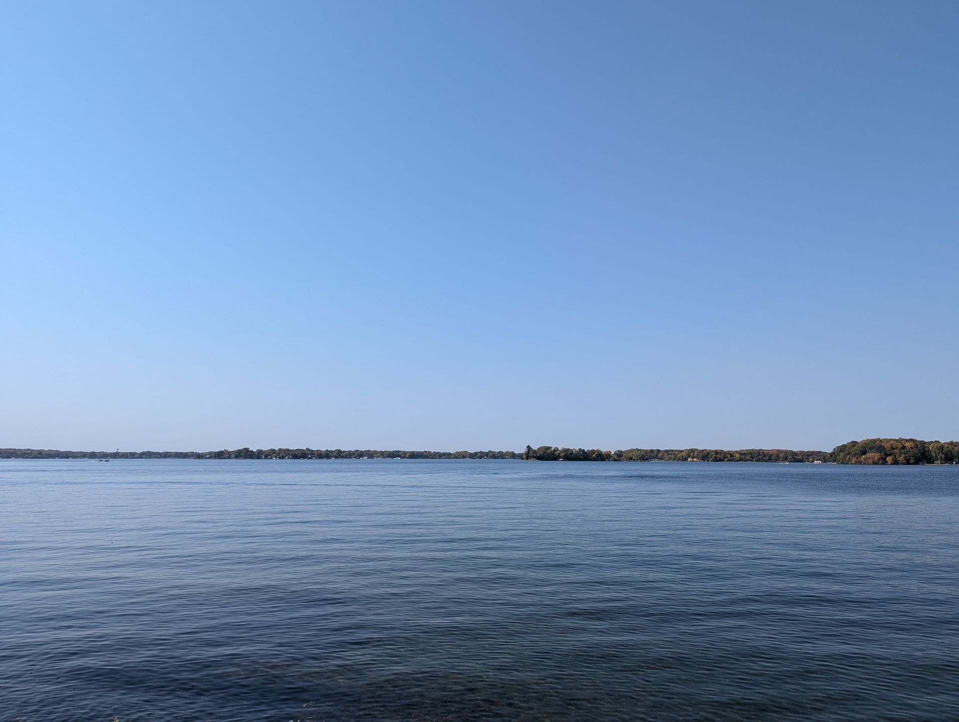 A large body of water with a blue sky in the background.