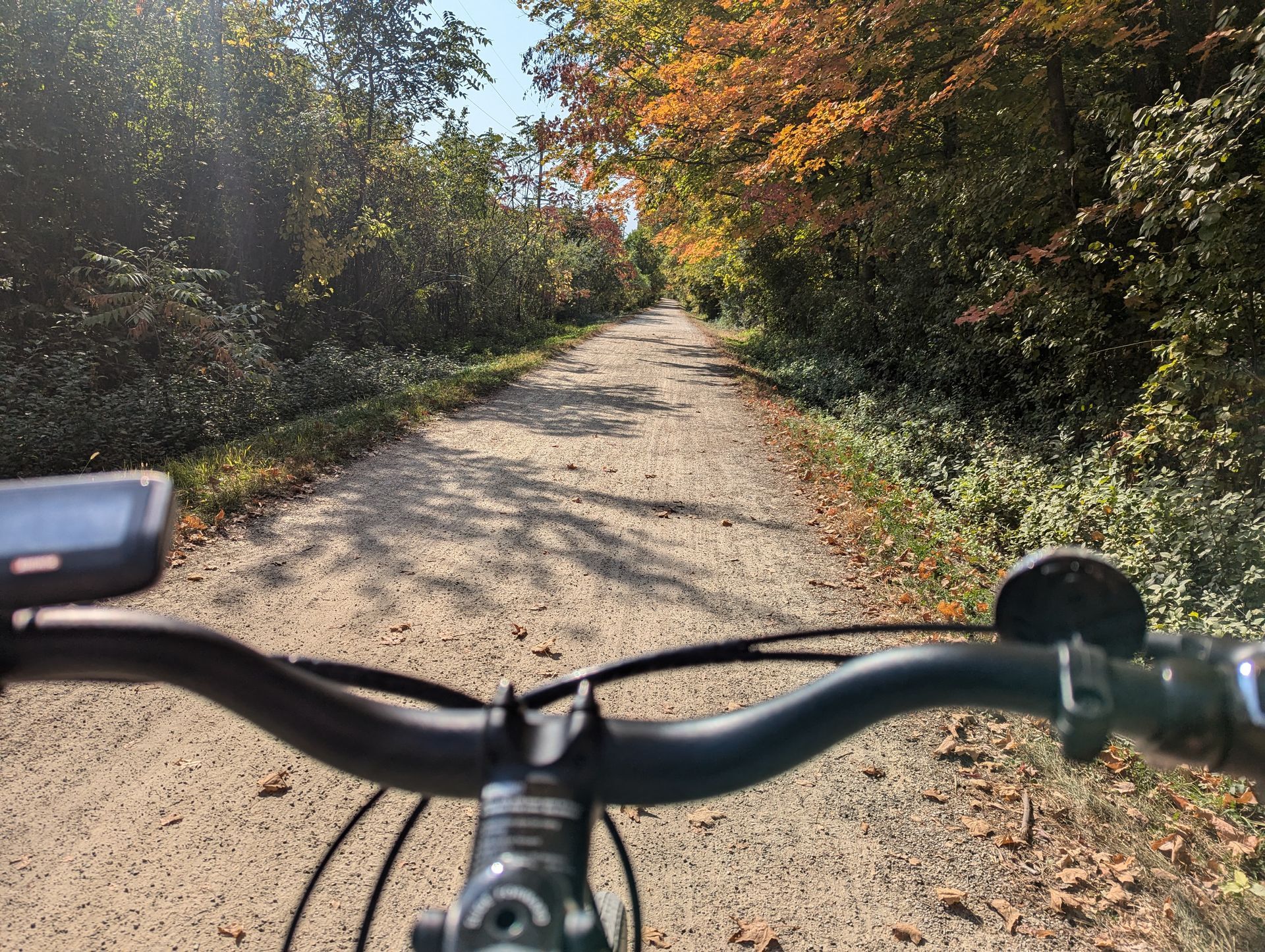 A person is riding a bike down a dirt road