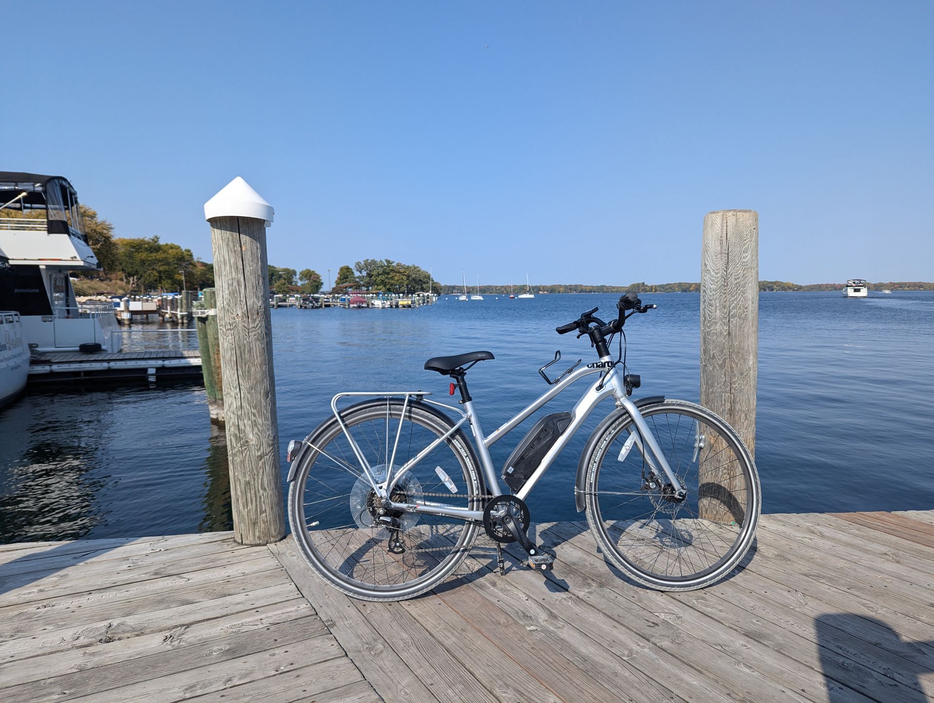 A bicycle is parked on a dock next to a body of water.