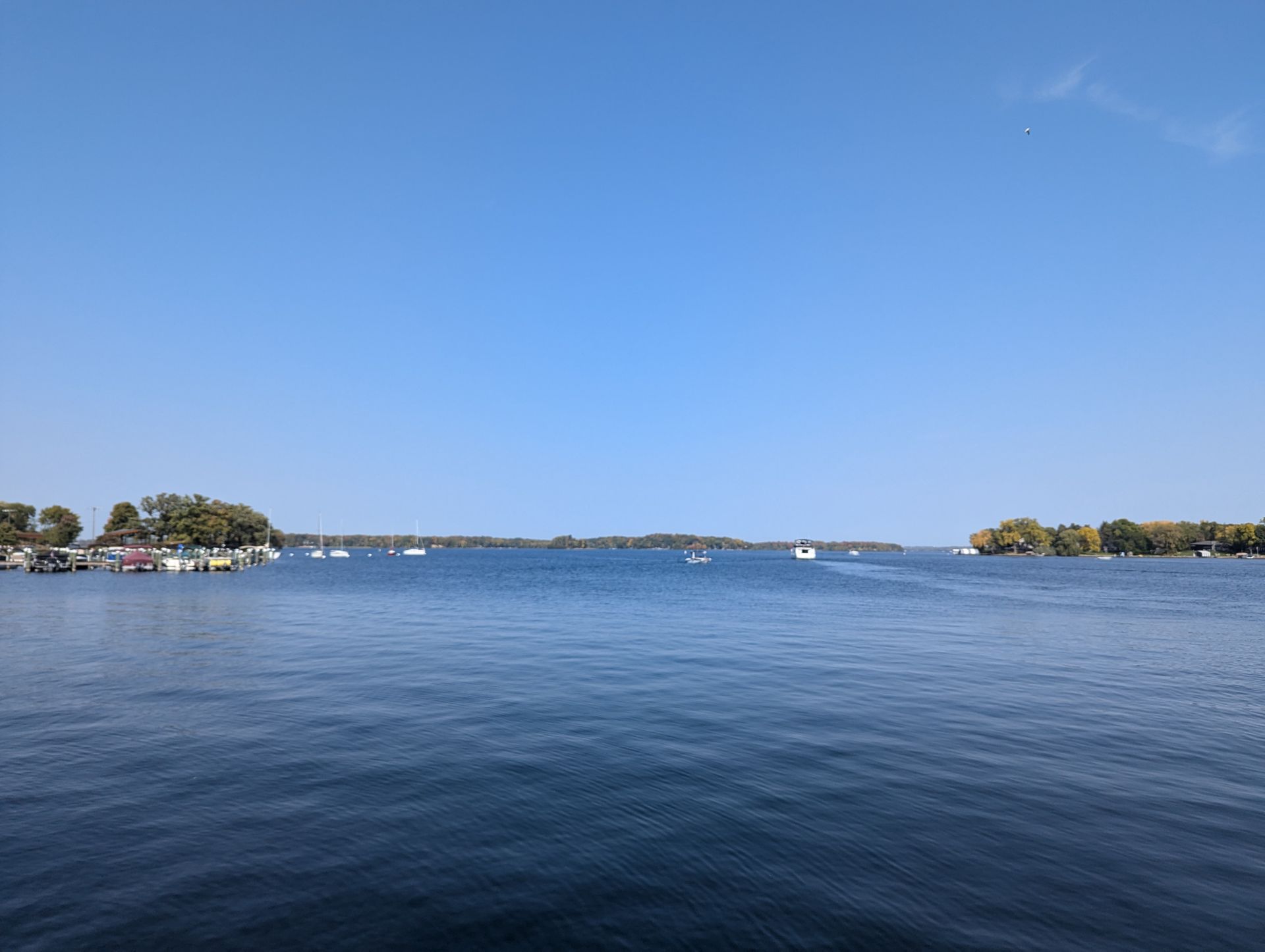 A large body of water with boats in it on a sunny day.