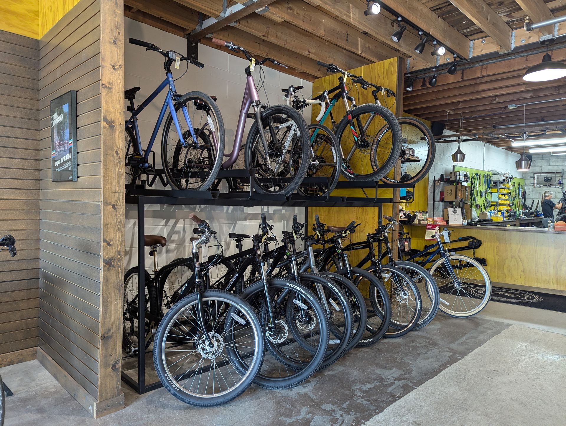 A row of bicycles are lined up on a rack in a bicycle shop.