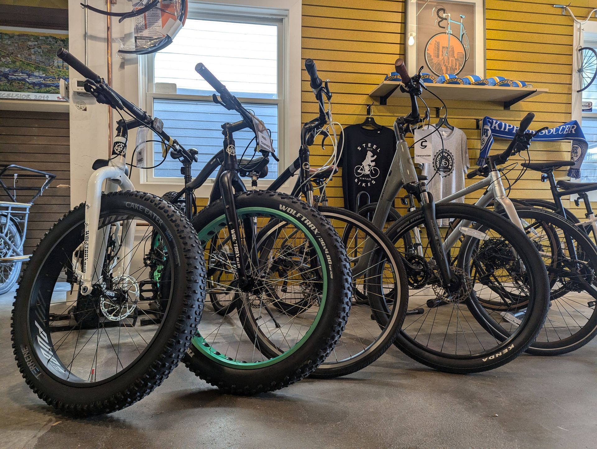 A row of bicycles are parked next to each other in a store.
