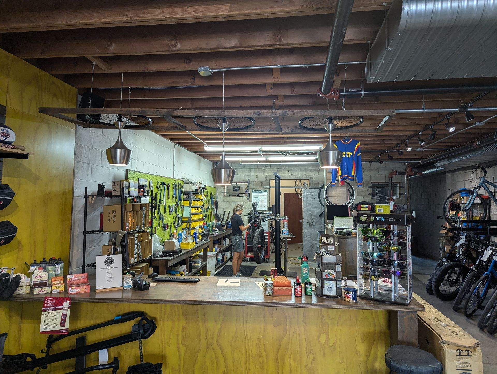 A bicycle shop with a counter and a bunch of bikes on the wall.