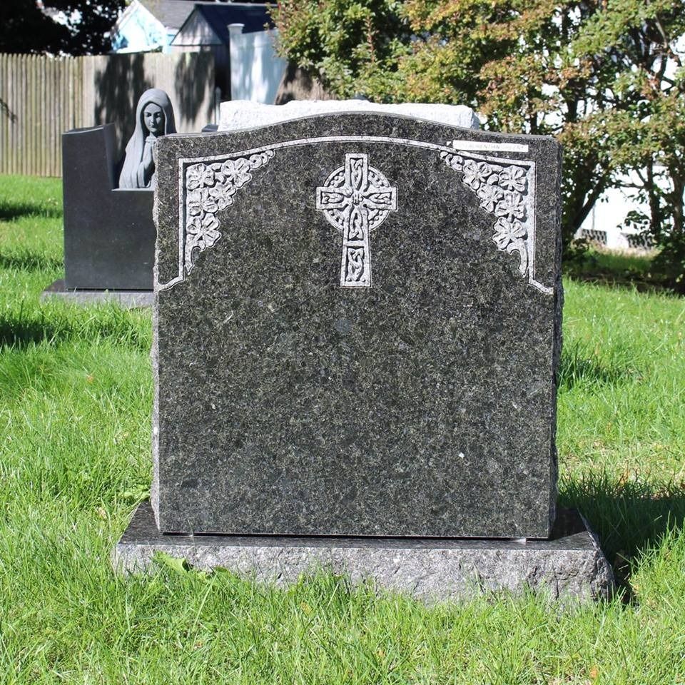 A gravestone with a cross on it