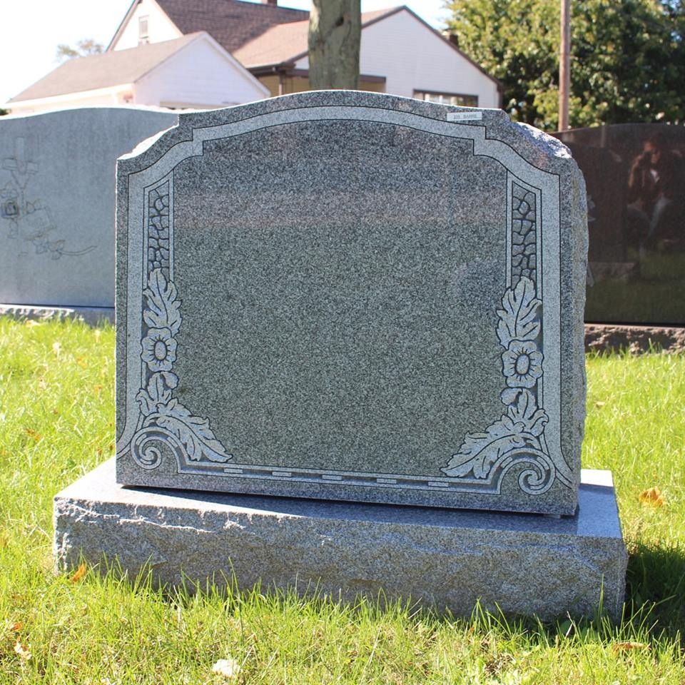A gravestone in a cemetery with a floral design on it