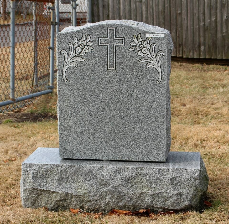 A gravestone with a cross and flowers on it
