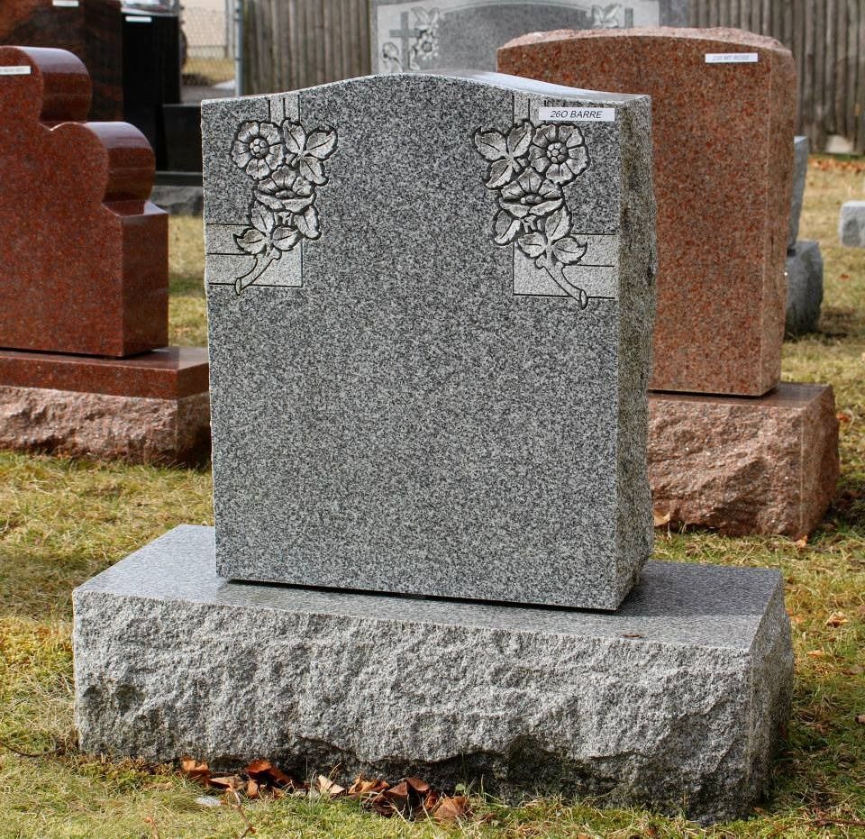 A gravestone in a cemetery with flowers on it