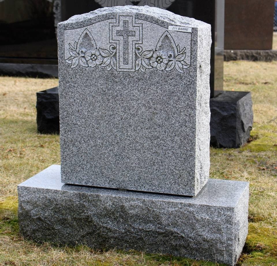 A gravestone with a cross on it in a cemetery