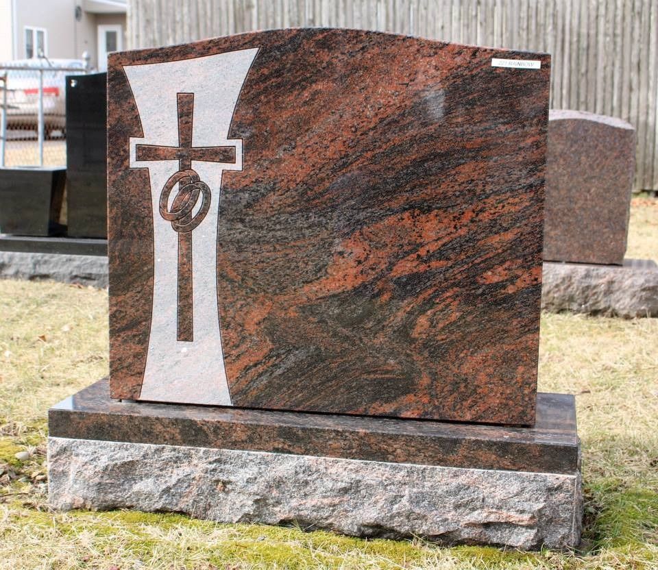 A gravestone with a cross on it in a cemetery