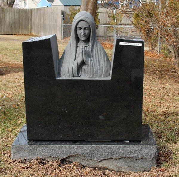 A statue of a woman in a veil is on a grave