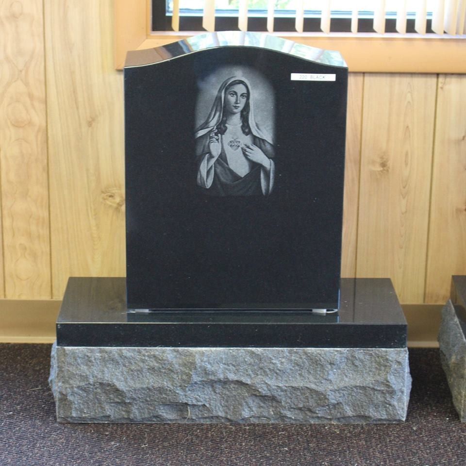 A black gravestone with a picture of a woman on it