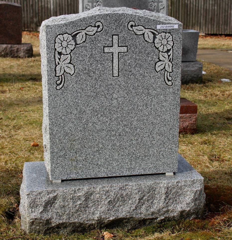 A gravestone with a cross and flowers on it
