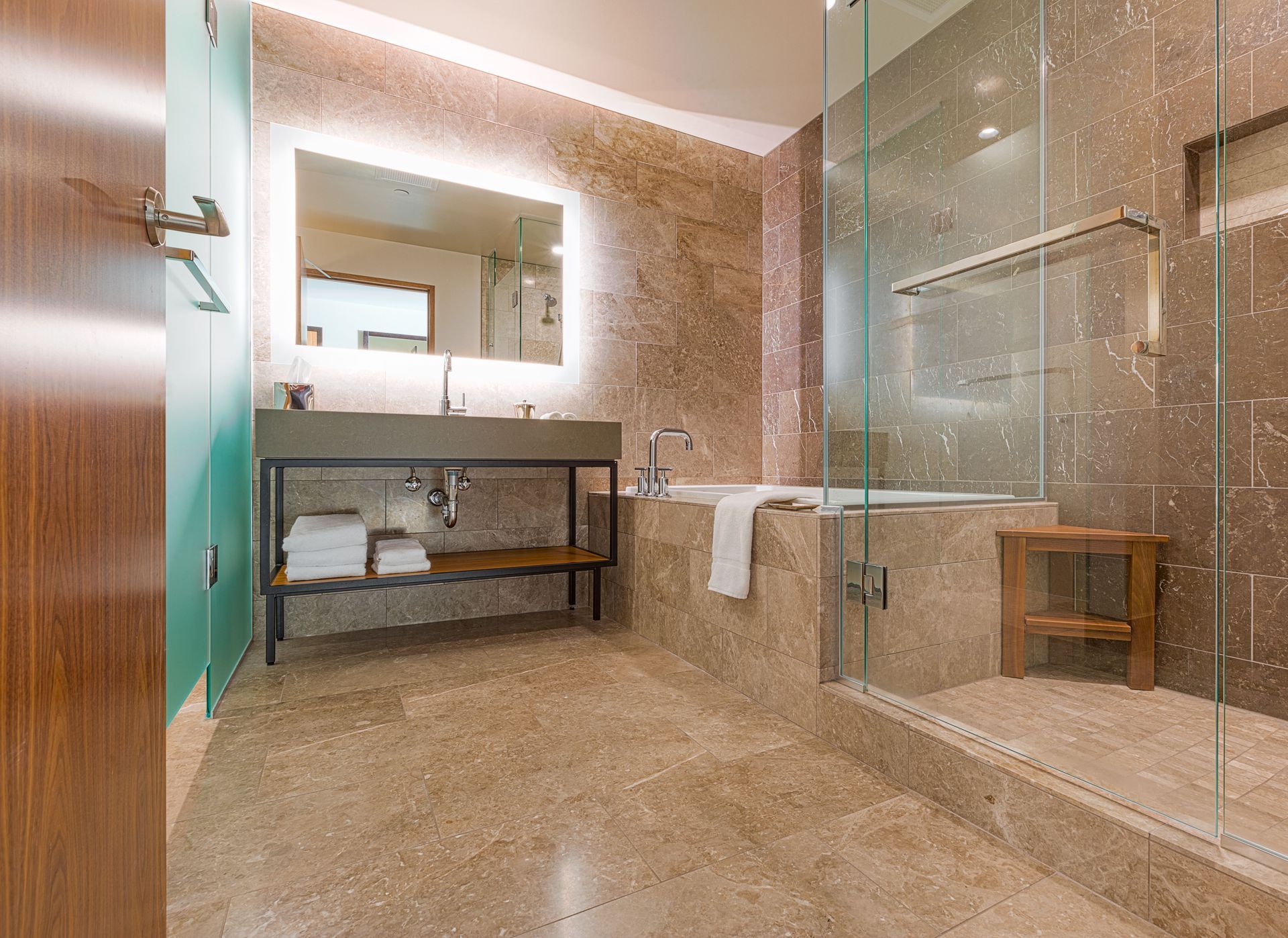 A bathroom with a sink , tub , shower and mirror.
