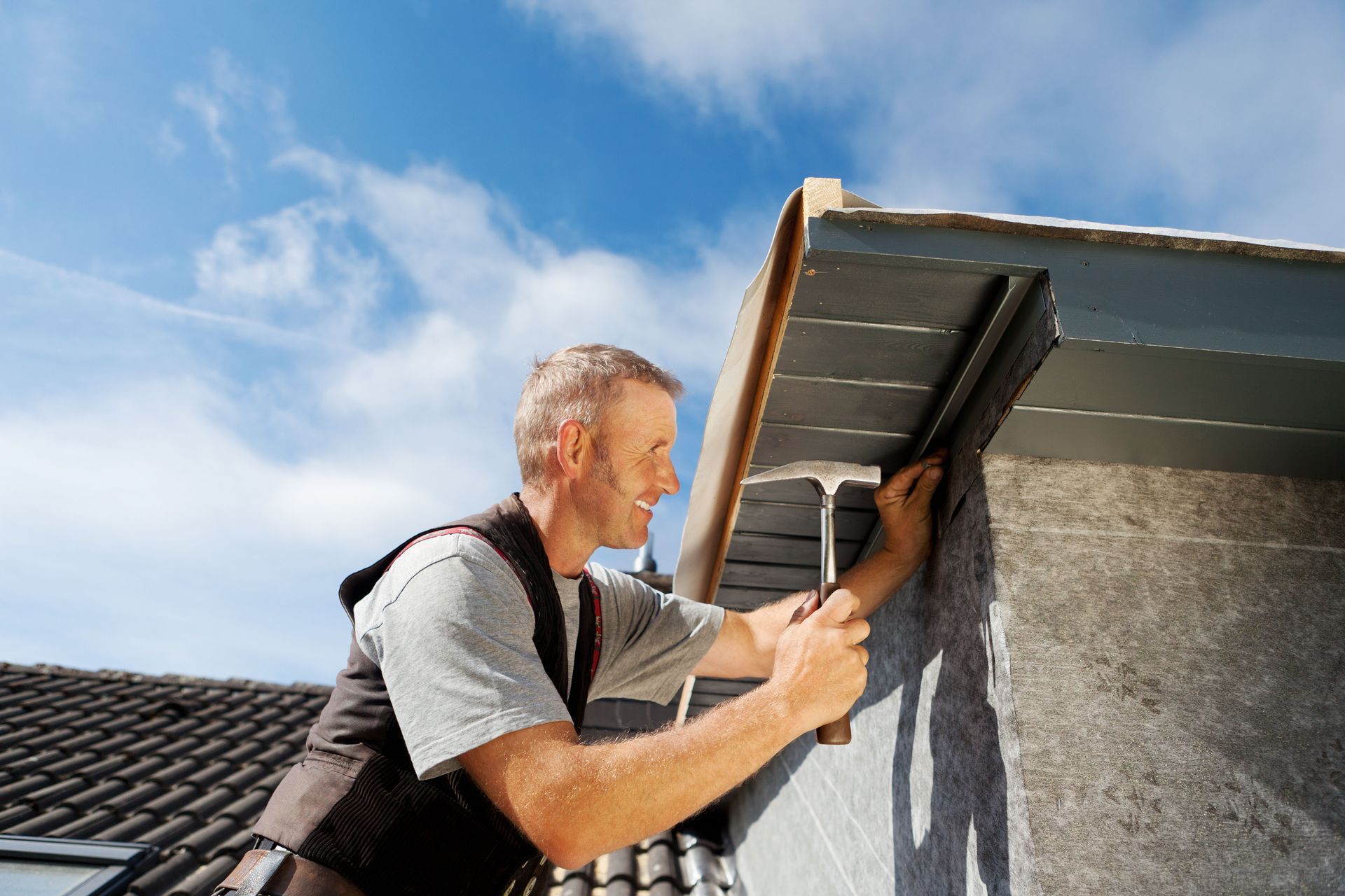 A man is working on the roof of a building.