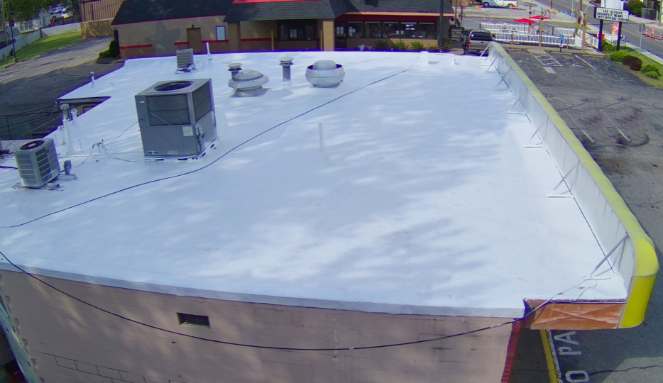 An aerial view of a roof of a building with a white roof.