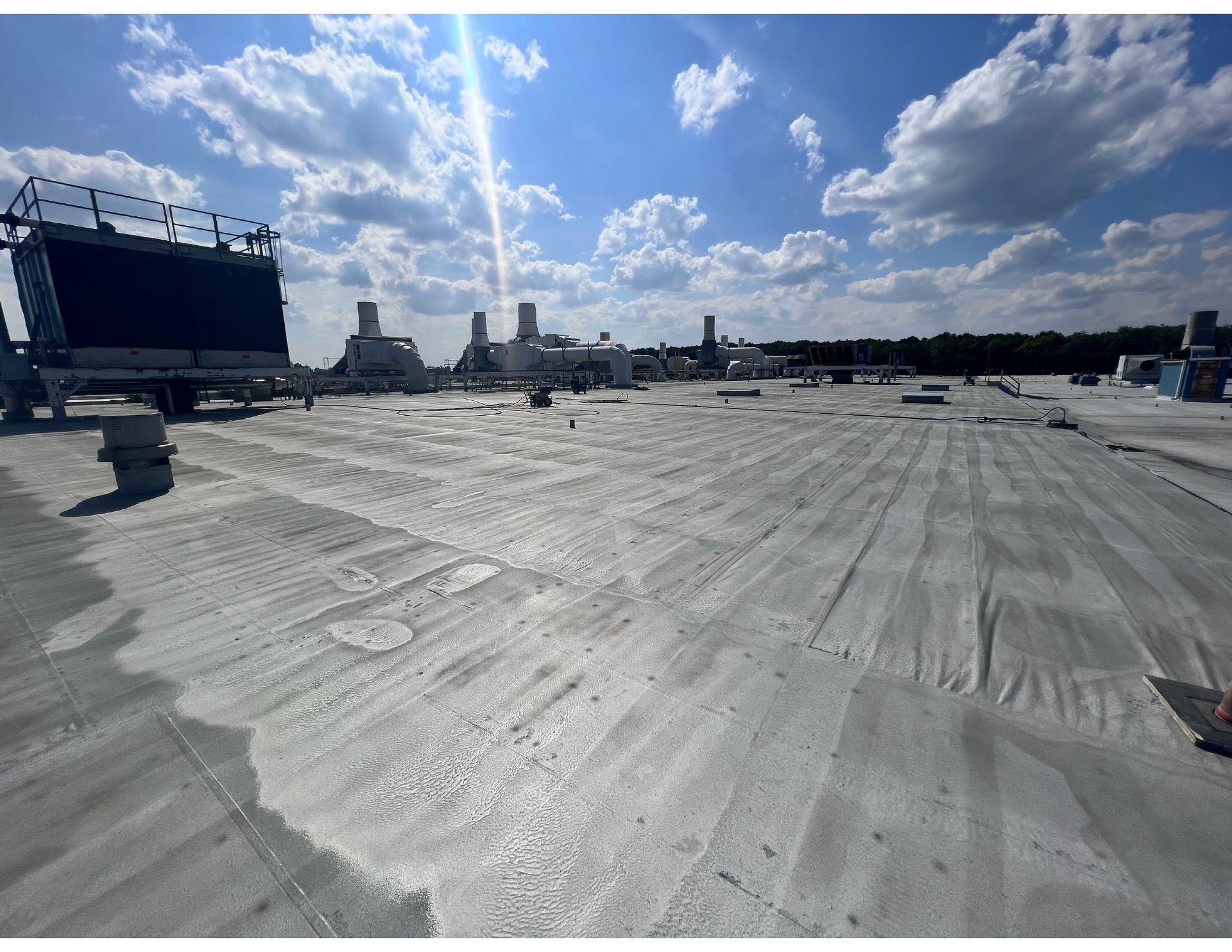 A large concrete roof with a blue sky and clouds in the background
