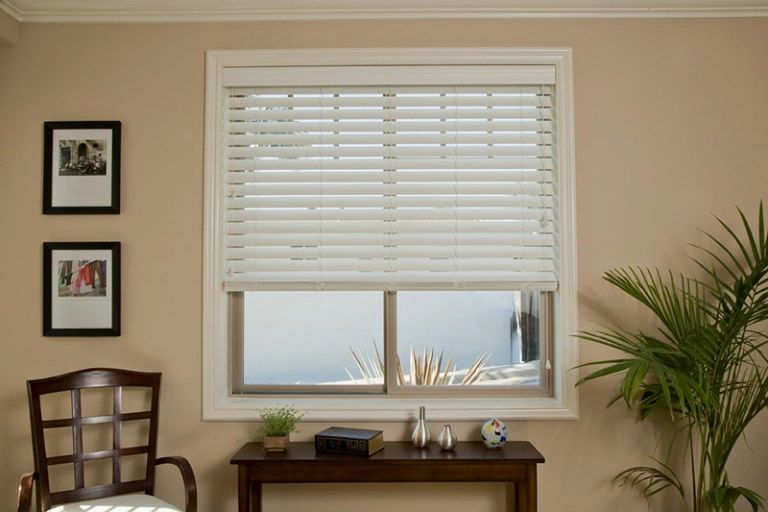 A living room with a table and chairs and a window with blinds