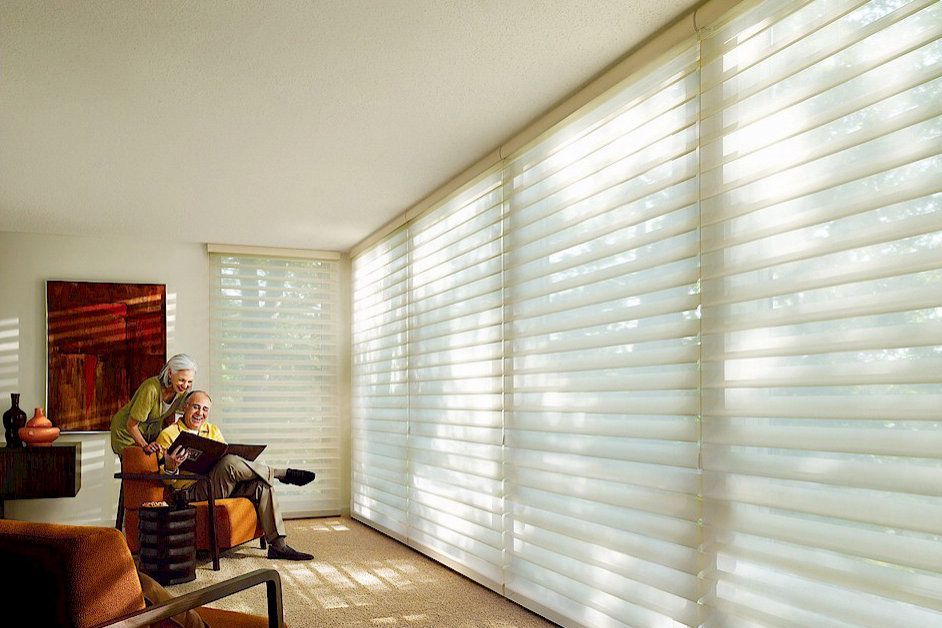 A man and woman are sitting on a couch in a living room.