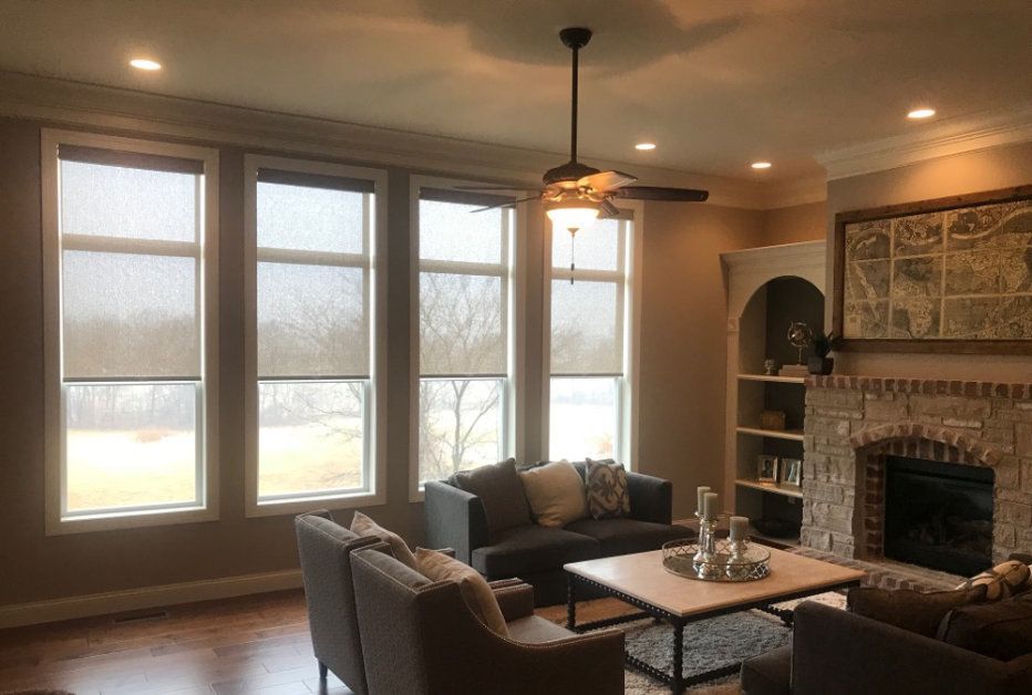 A living room with a couch , chairs , coffee table and fireplace.