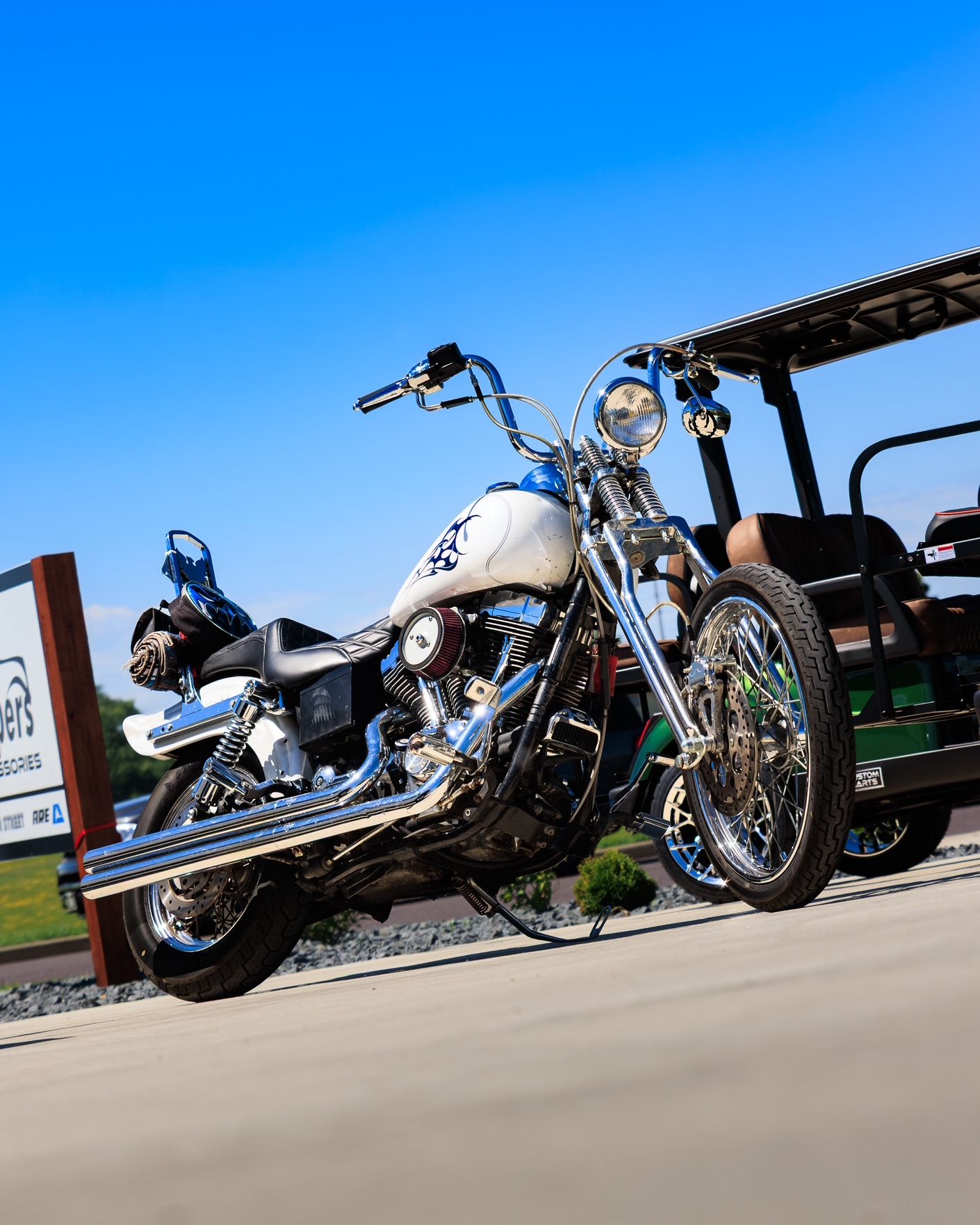 Chrome motorcycle parked outdoors under a bright blue sky