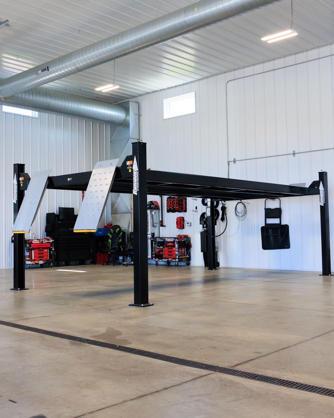 Industrial workshop with a black metal lift frame inside a clean garage space