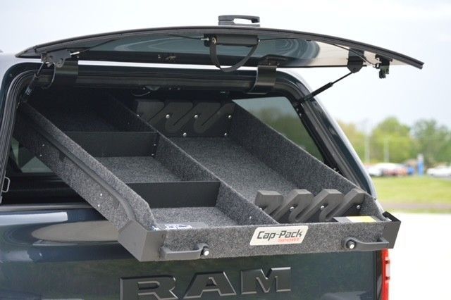 Black pickup truck with an open canopy and pull-out storage drawers in the bed
