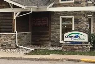 Stone building entrance with a sign reading “Community Eyecare Center” by the doorway.