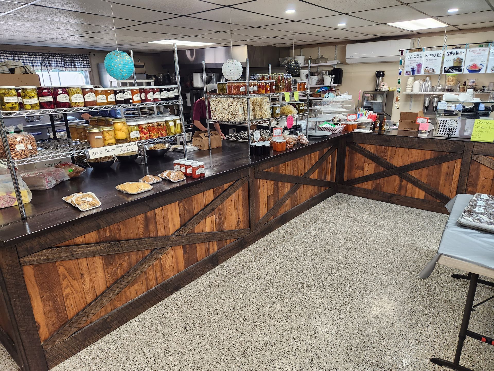 A bakery with a long wooden counter and a table.