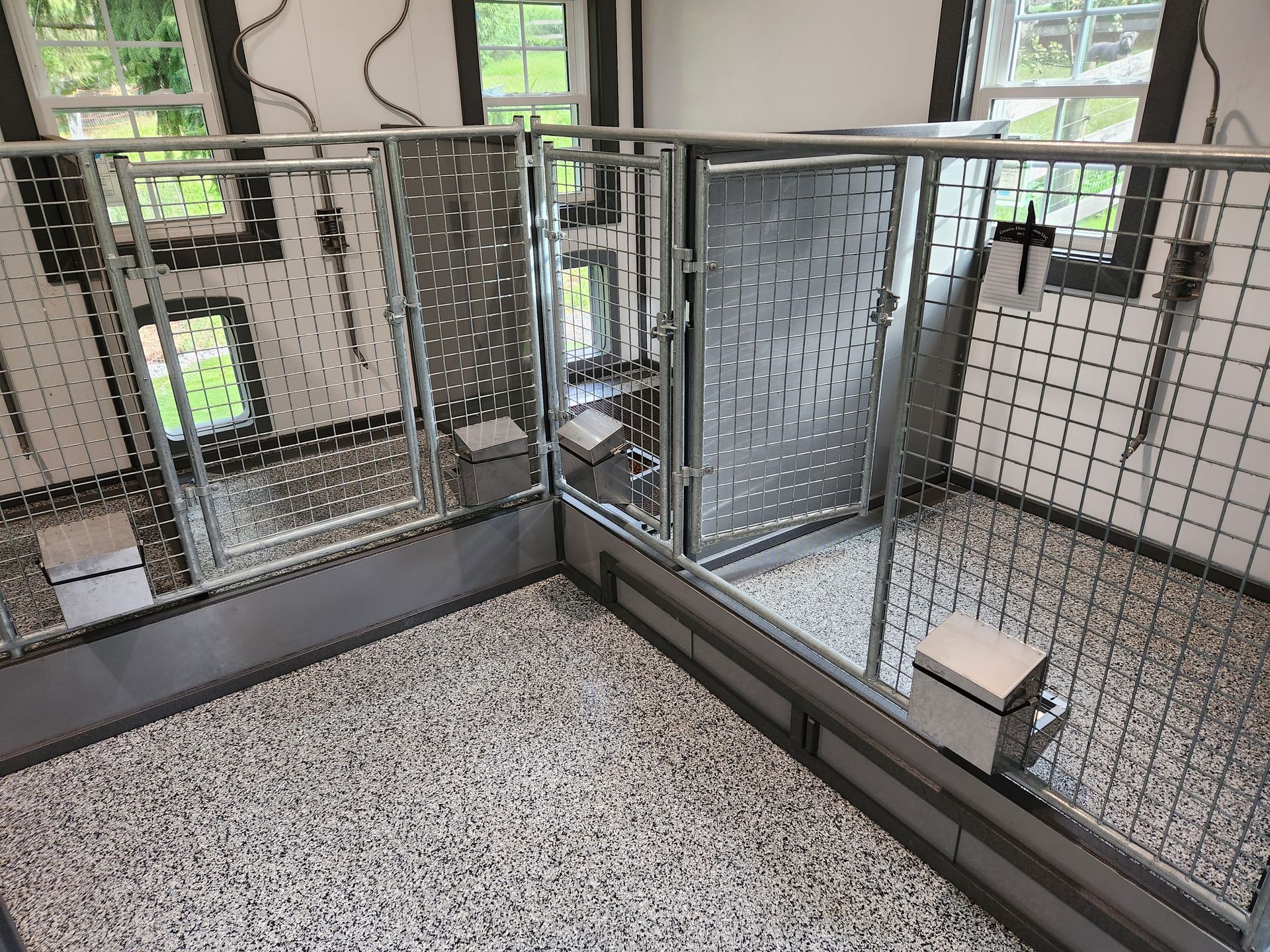 A dog kennel with a fence and a stool in it.