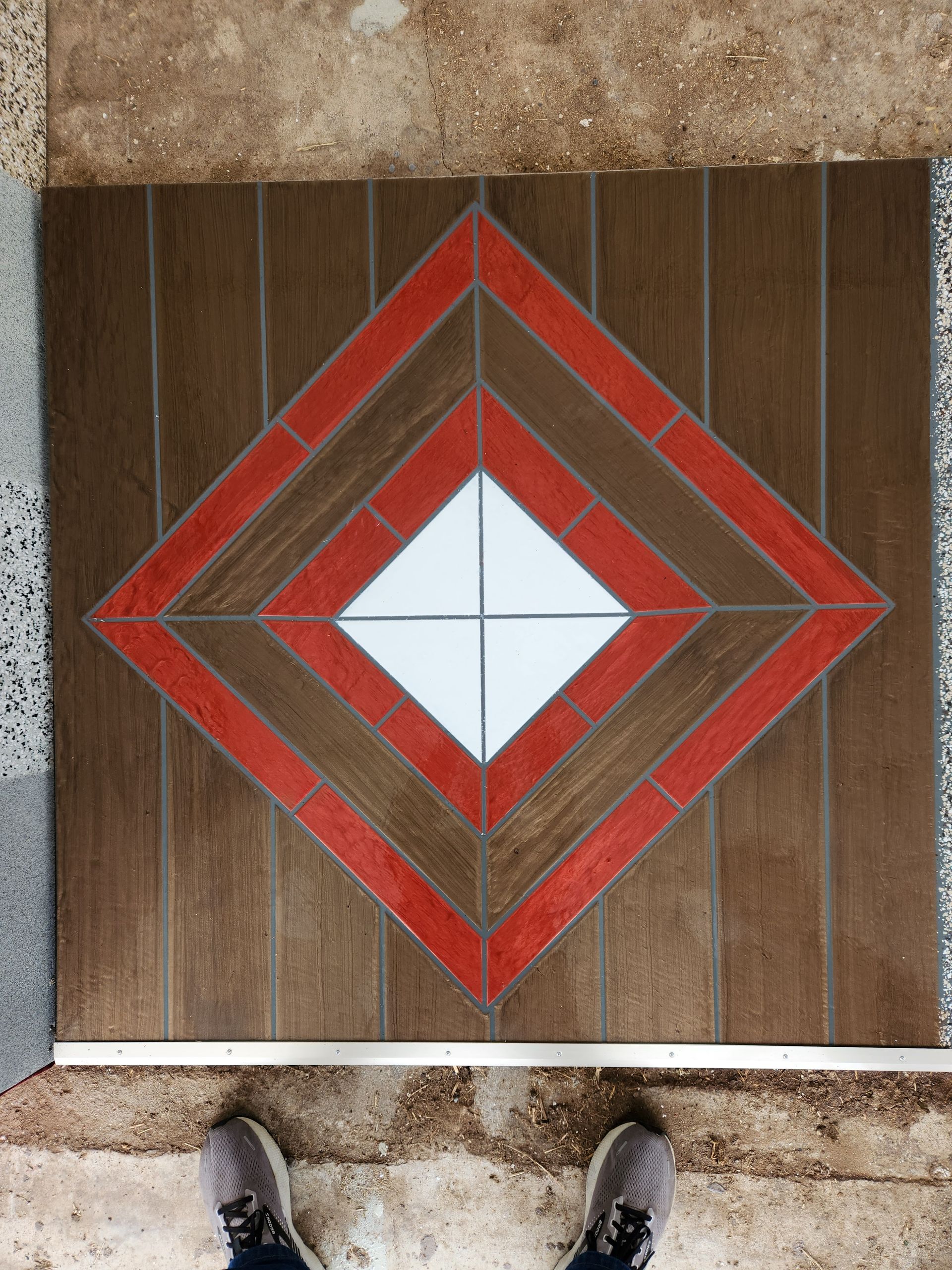 A person is standing on a tile floor with a diamond design