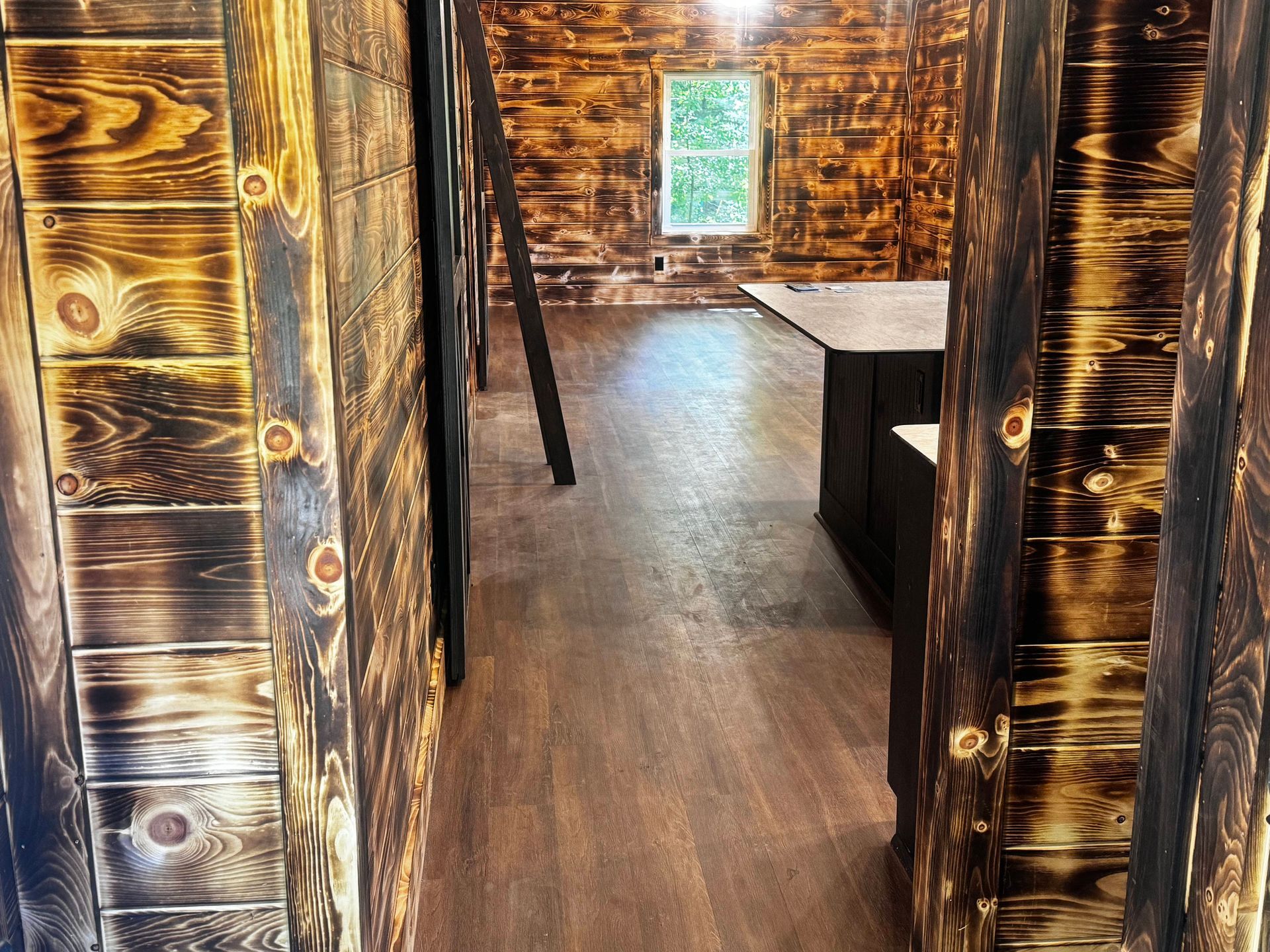 A hallway with wooden walls and a wooden floor