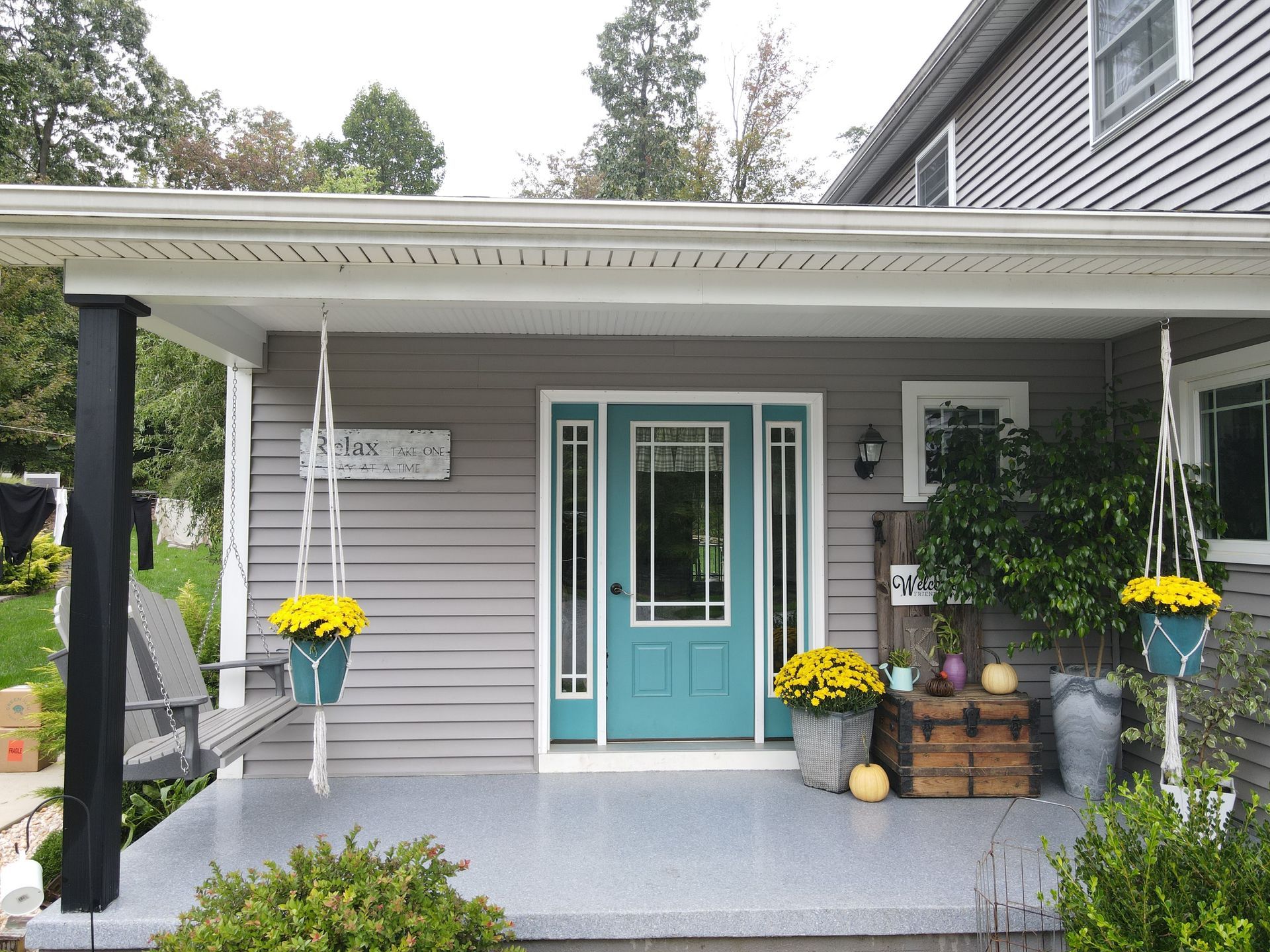 A house with a blue door and a porch decorated for fall