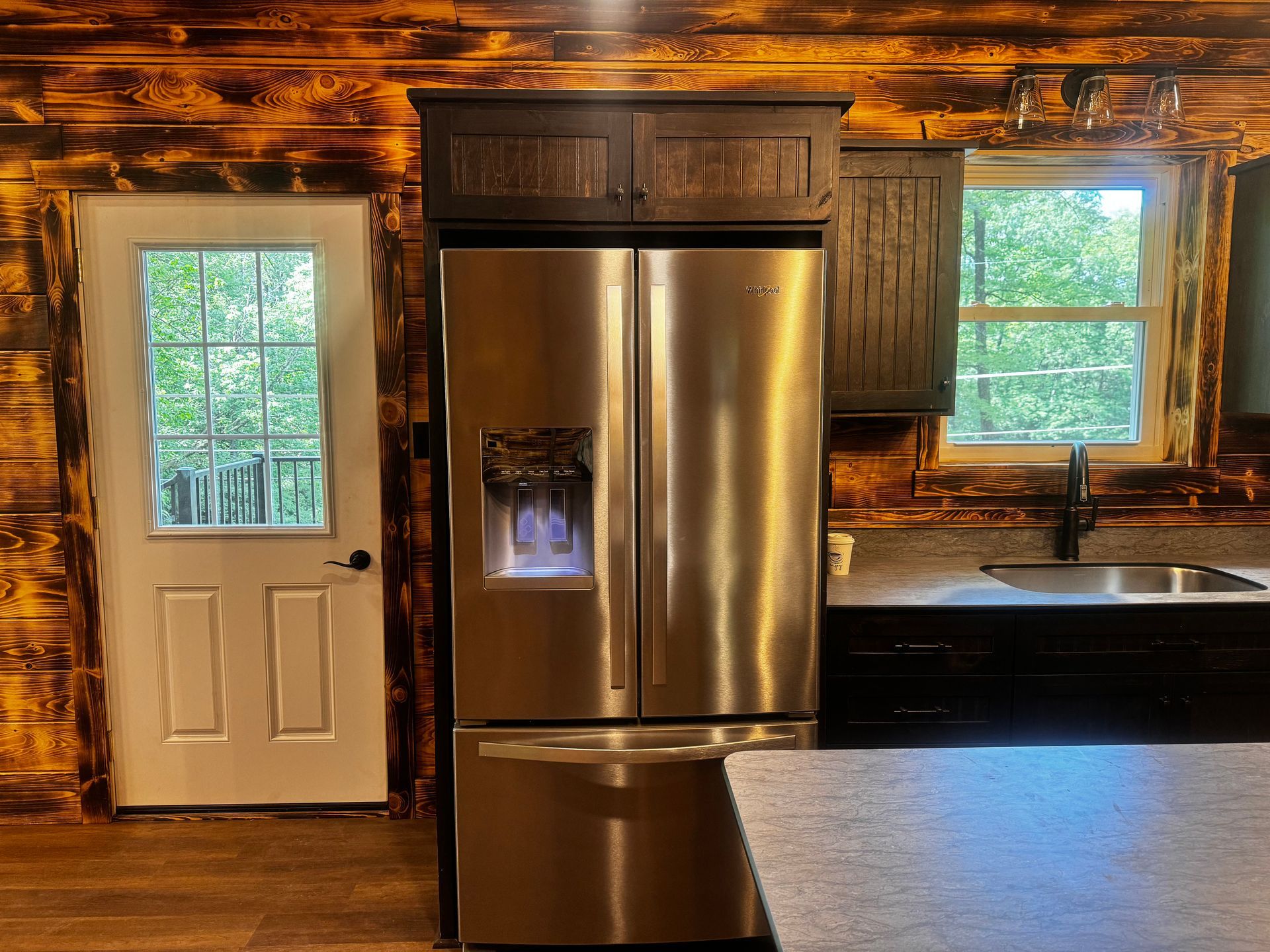 A kitchen with a stainless steel refrigerator and a sink.