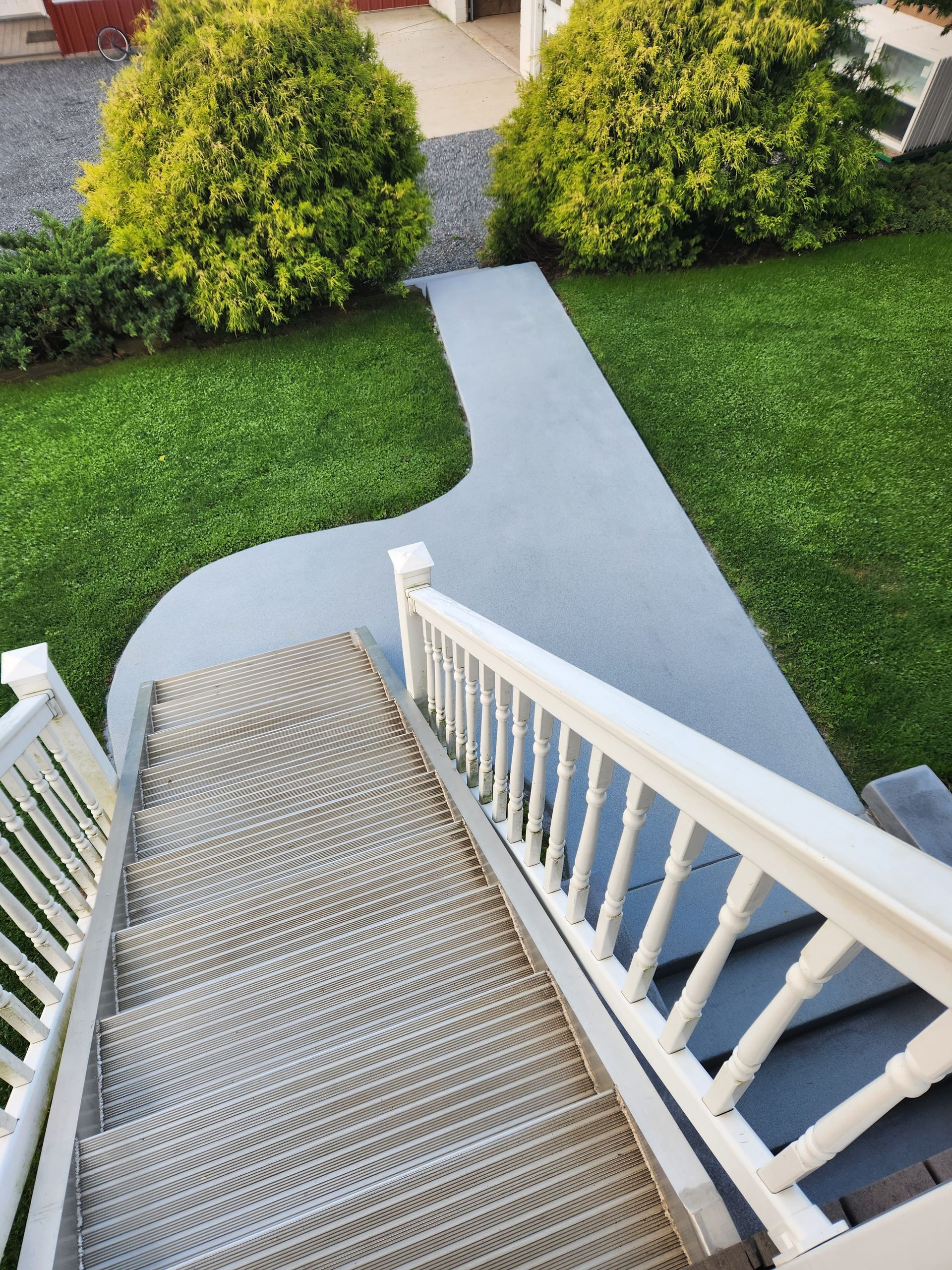 A set of stairs leading up to a house with a white railing