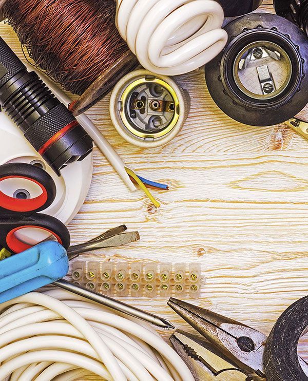 Electrical tools and components arranged on a wooden surface.