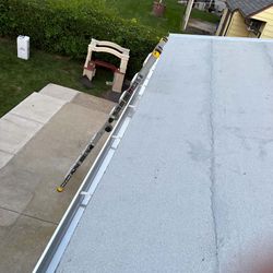 A roof with a gutter and a ladder attached to it