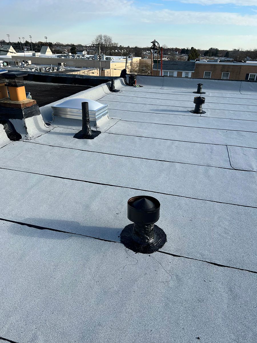 A white roof with a black chimney on top of it.