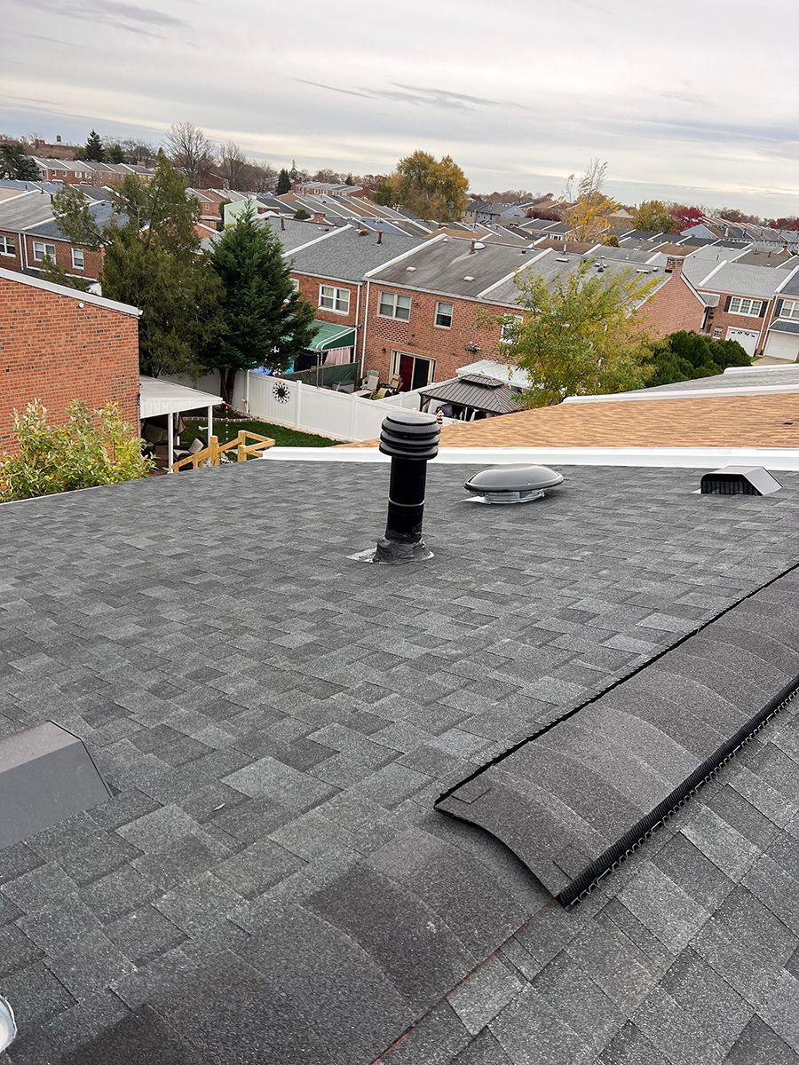 A roof with a chimney on it and a view of a city.