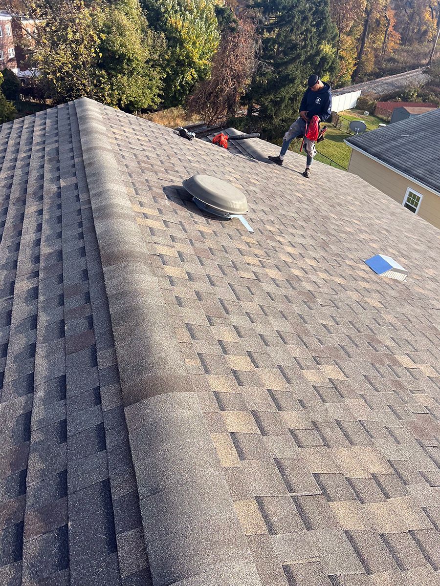 A man is standing on top of a roof.