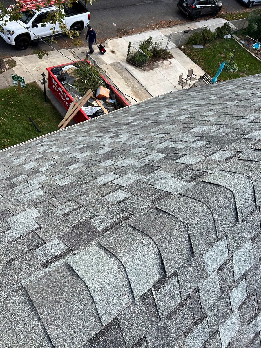 A man is standing on the roof of a house.