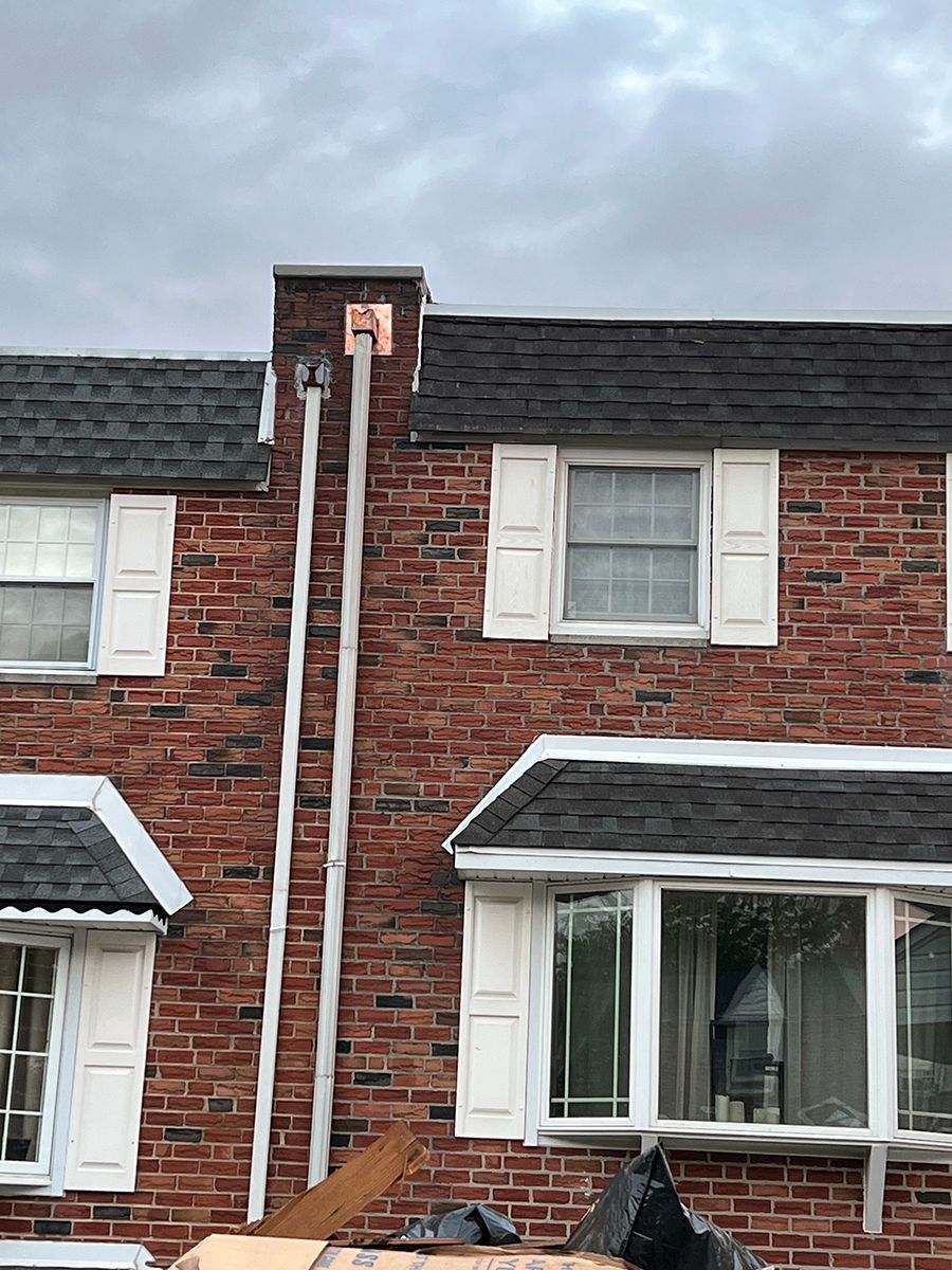 A brick house with a chimney on the side of it.