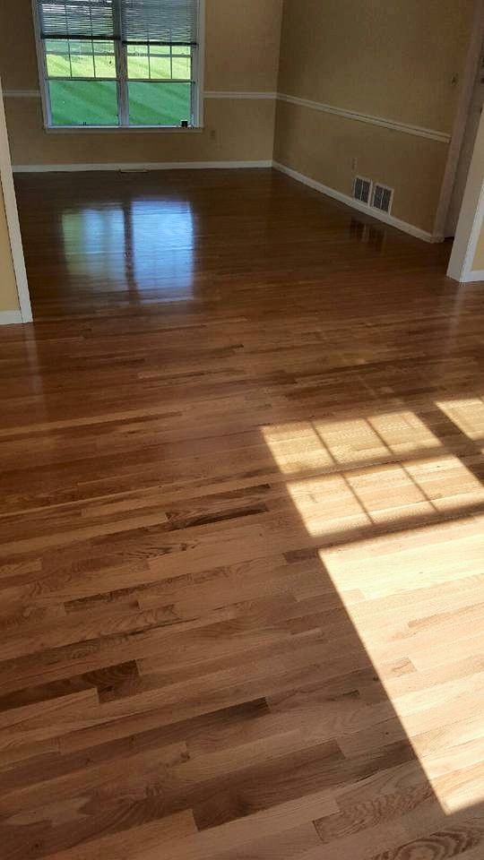 A living room with hardwood floors and a window.