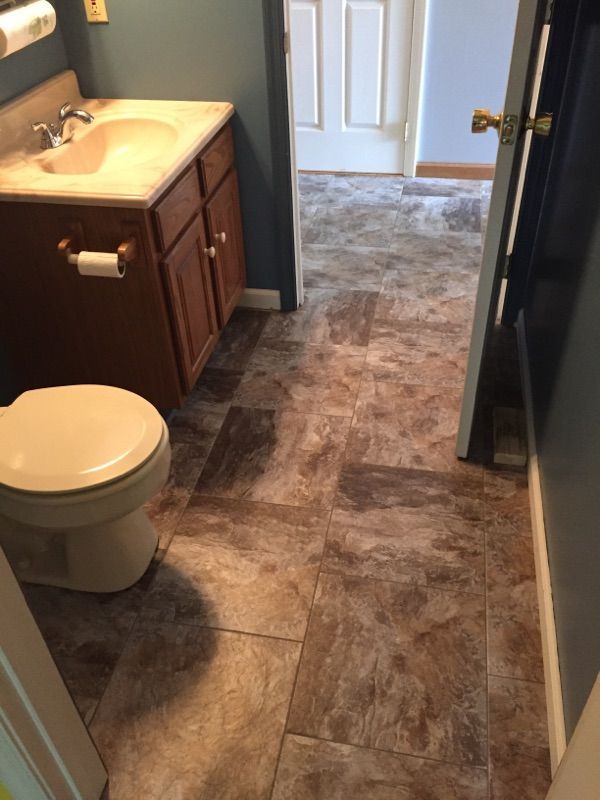 A bathroom with a toilet , sink and tile floor